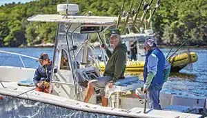 sea tow member fishing with family - yellow sea tow boat in background