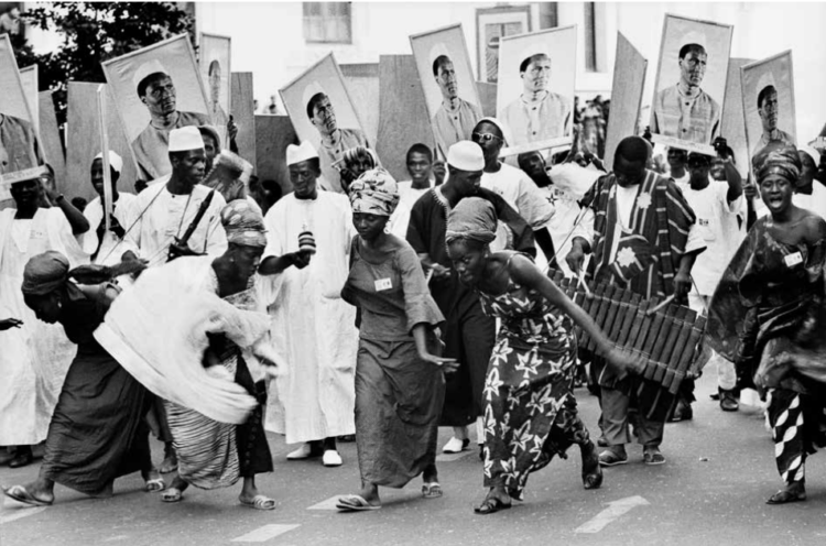 Folk troupe from Guinea during the inaugural parade of PANAF, July 1969. On the placards is a portrait of Ahmed Sékou Touré, president of the Republic of Guinea. © Guy Le Querrec/Magnum Photos. Photo: Guy Le Querrec